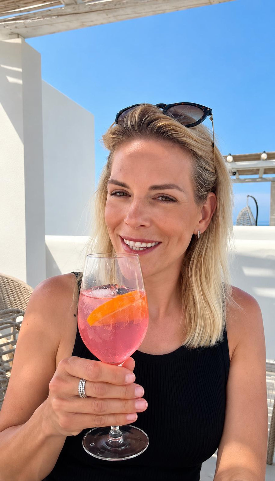 Blonde Frau mit Glas im Urlaub
